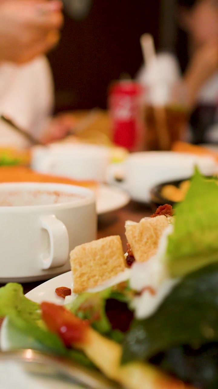 Un primo piano di ciotole di insalata e zuppa salutari su un tavolo in un ristorante.