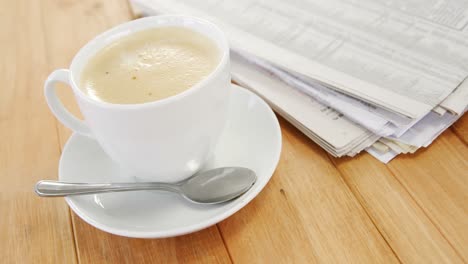 coffee and newspaper on wooden plank