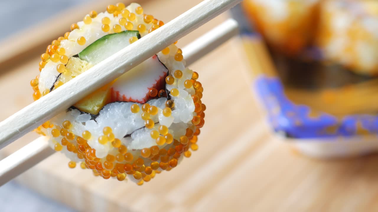primer plano de un rollo de sushi con palillos