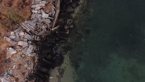 Drone-flying-up-a-rocky-sea-shore-in-Odessa,-Ukraine