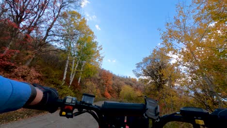 montar un vehículo de cuatro ruedas fuera de carretera a lo largo de una carretera de montaña en otoño - vista en primera persona