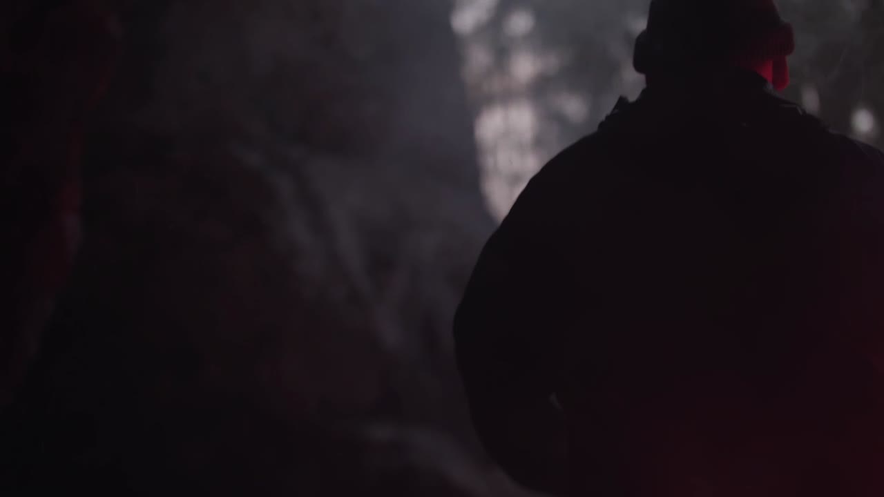 persona en el bosque por la noche con luz roja y humo