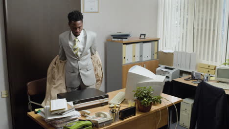 un hombre de negocios afroamericano entrando en la oficina de vintage.