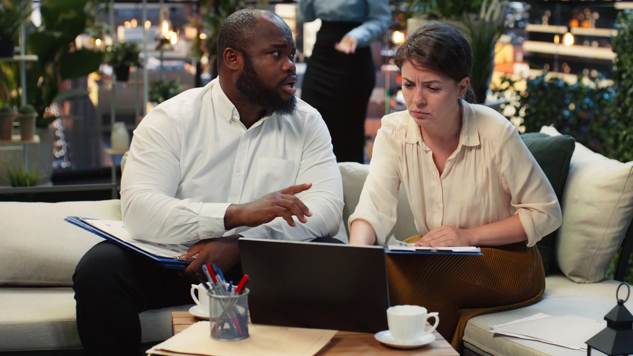 Coworkers comparing printed report during rooftop meeting