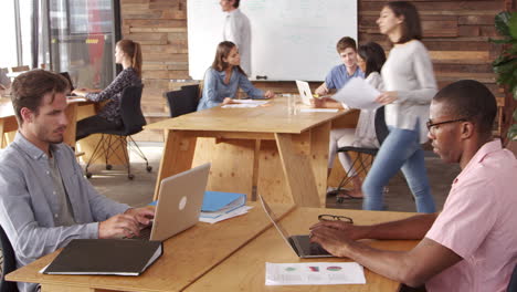 young business colleagues working in a busy open plan office