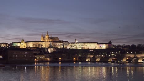 Castillo-De-Praga-Y-Puente-De-Carlos-Con-Un-Cielo-Increíble-Lleno-De-Pájaros,-Vista-Romántica-Nocturna