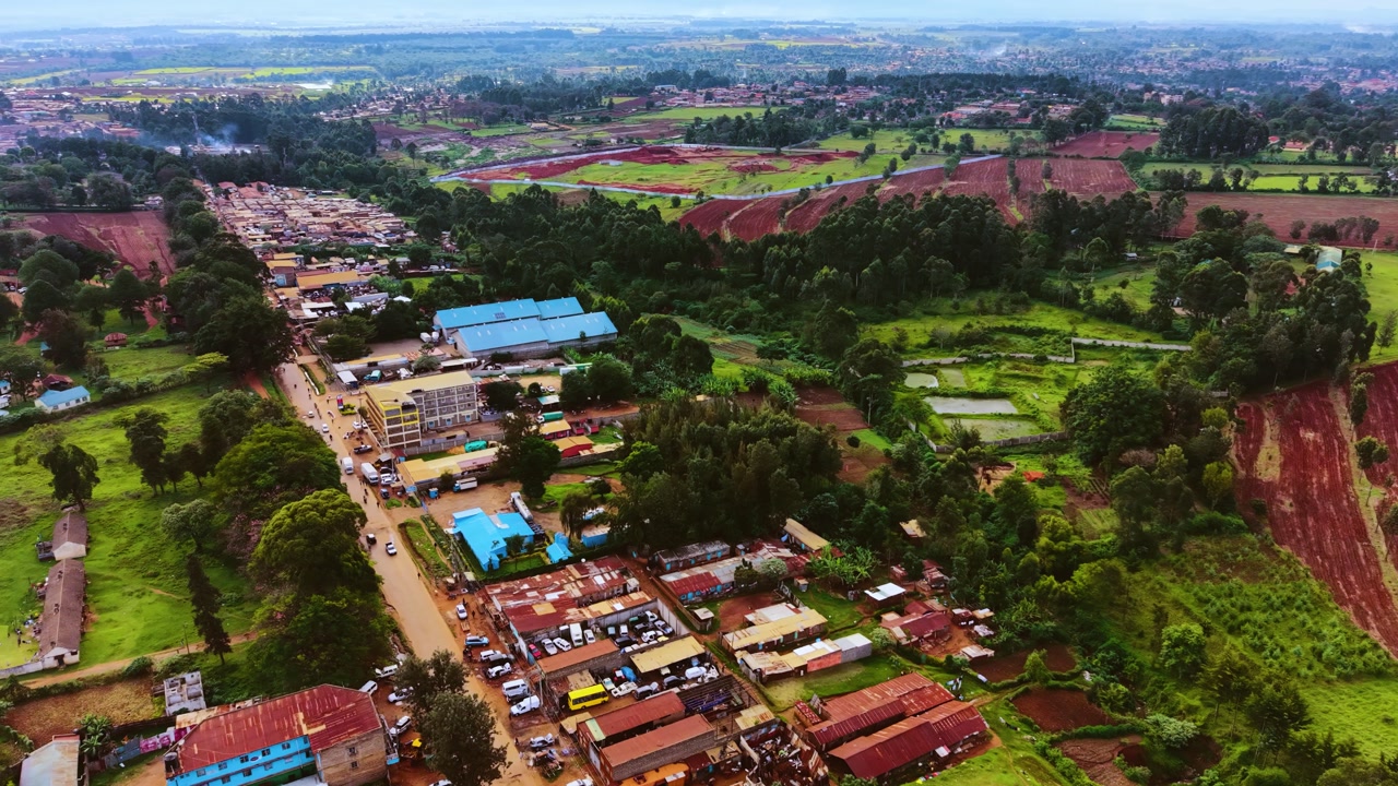 Aerial flyover poor Kitale Slum and modern skyline of Kitale rural urban area of kenya during sunny day. Two class society in Africa.