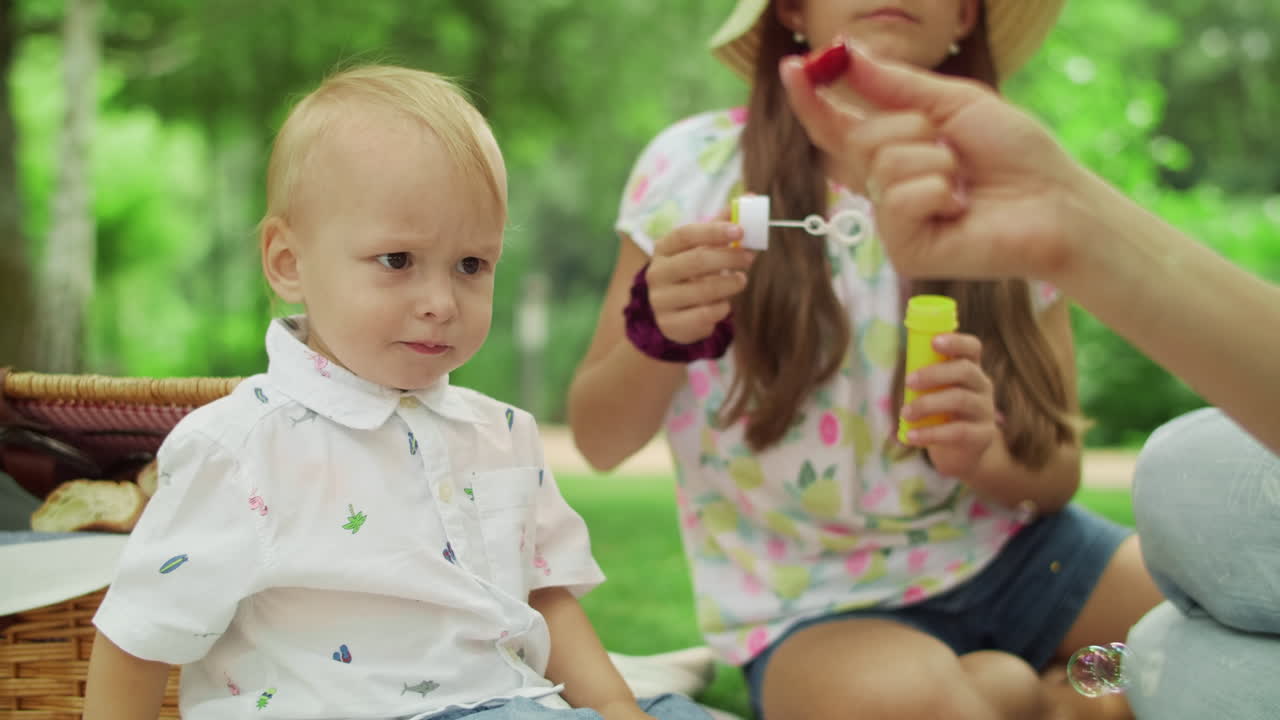 familia divirtiéndose en el bosque de verano. niños y padres femeninos relajándose en el parque