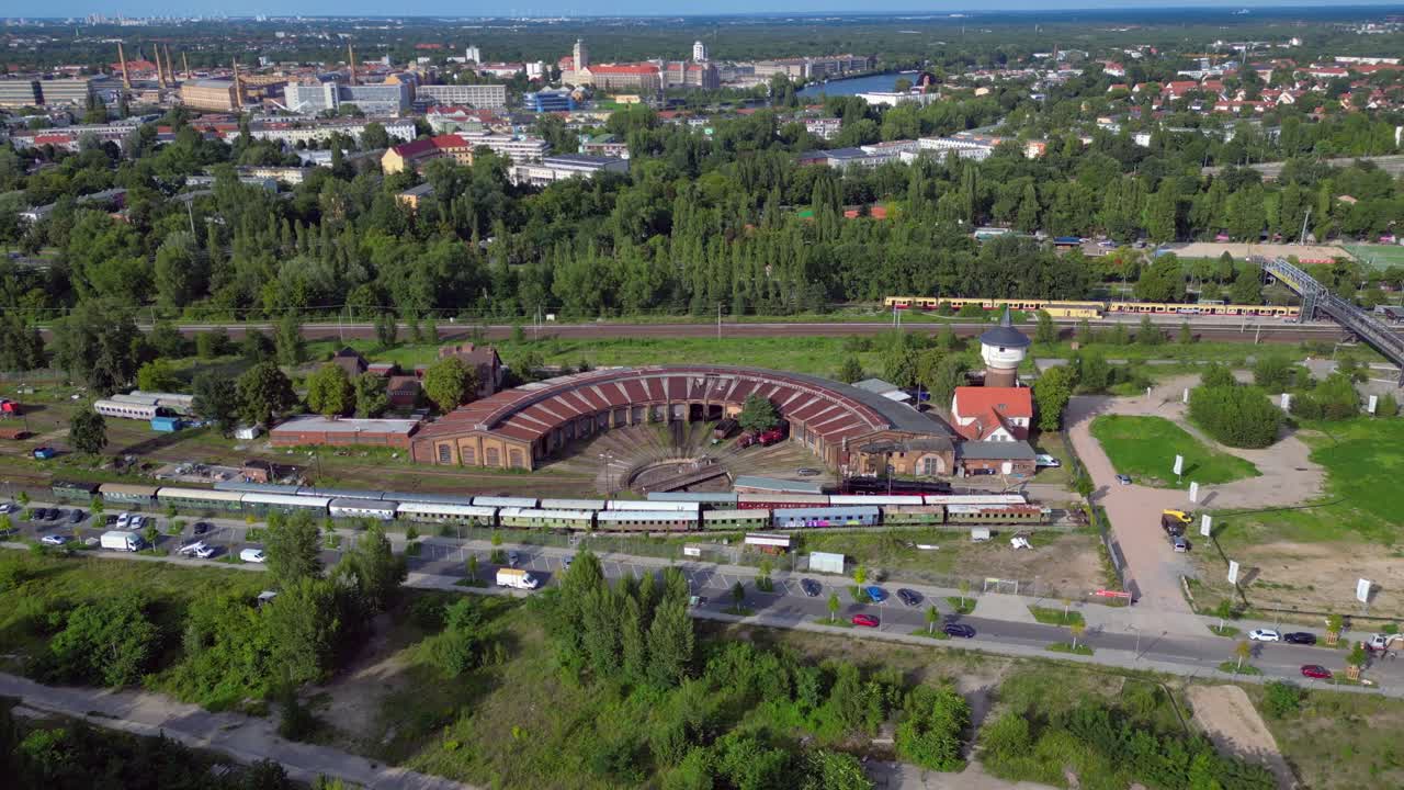 historic steam locomotive shed and trains depot with surrounding urban city Berlin Germany landscape, industrial heritage. Majestic aerial view flight fly push forward drone