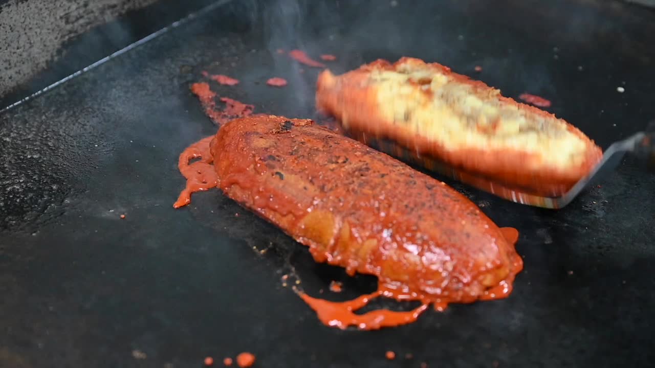 레스토랑에서 토마토 소스와 함께 토스트되고 있는 버거  ⁇