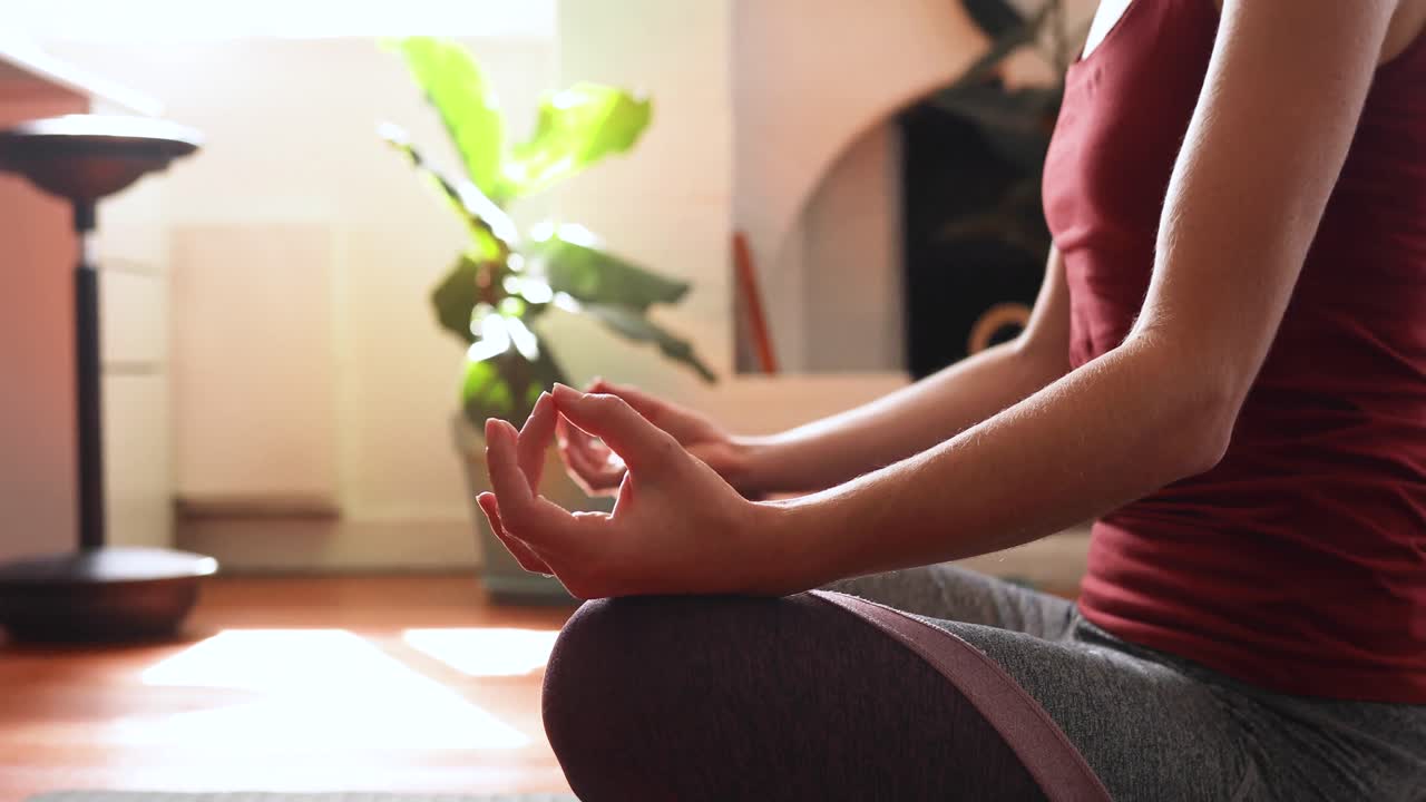 mujer caucásica practicando yoga en casa