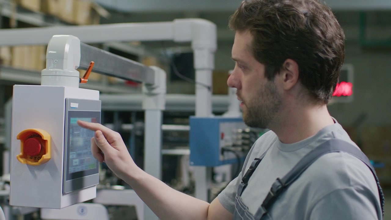 Technician Using Control Panel of Printing Machine in Commercial Print Shop