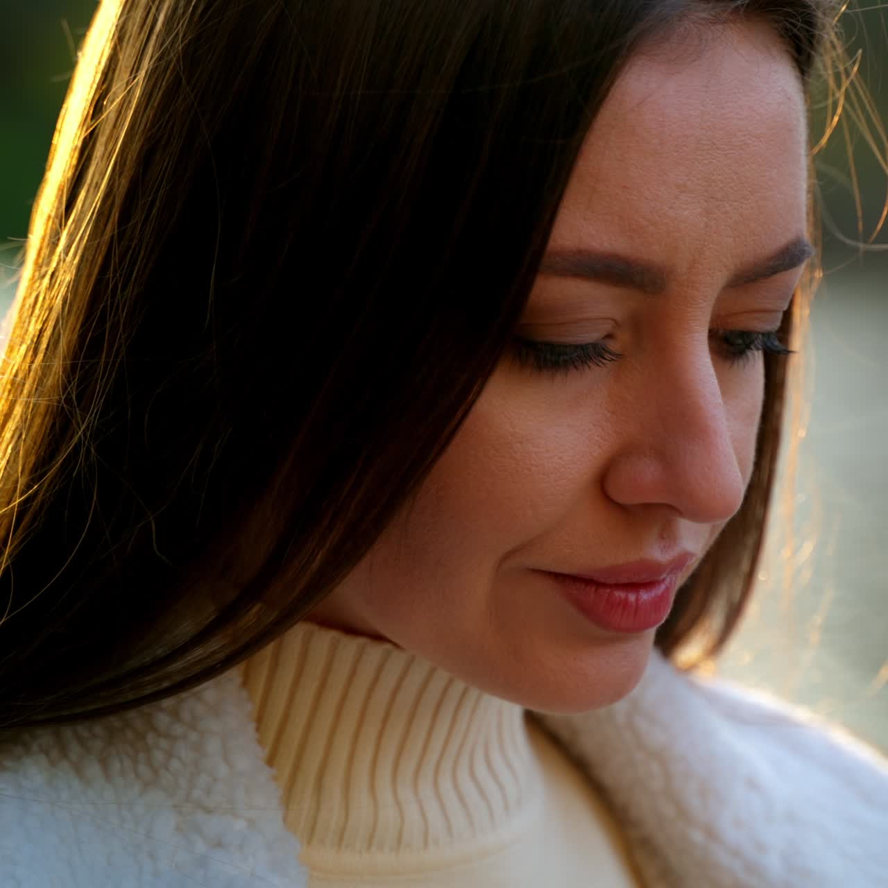 Approaching a beautiful lady standing with phone near the river. Focused woman looking at her phone outdoors. Autumn day backdrop. Close up