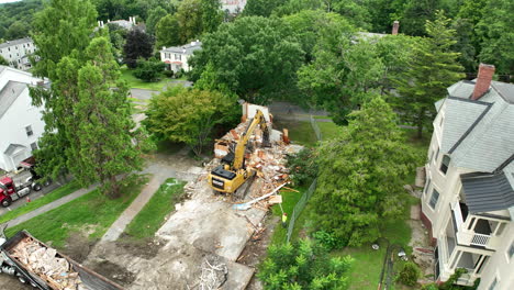northampton, massachusetts, usa - an excavator in the process of demolishing an old house - aerial drone shot