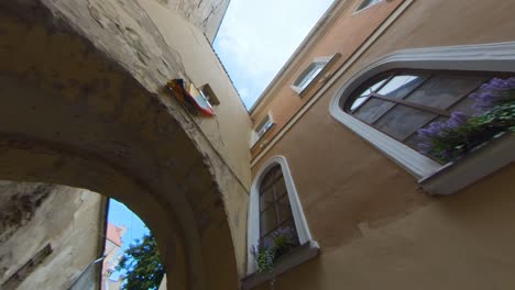 Bandera-Lituana-Sobre-El-Arco-En-La-Estrecha-Calle-Del-Casco-Antiguo-De-Vilna,-Lituania.