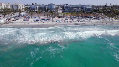 video aéreo volando sobre el agua hacia la playa en oceanside, ca