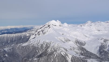 Snow-Covered-Mountains-Aerial-View---Sunny-Day