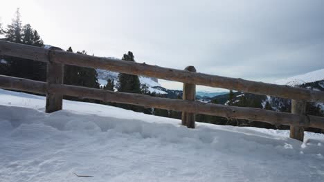 Snowy-mountain-trail-with-wooden-fence