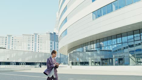 businesswoman using tablet outside modern building