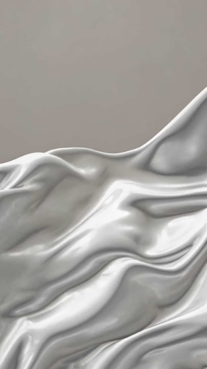 Close-up video of flowing, silky white fabric, capturing smooth, elegant waves from a low-angle
