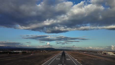 pilot’s fpv approach tom land at palma de mallorca’s airport runway with a blue sky covered with some white and grey stratus clouds recorded with the late afternoon light. 4k 60fps