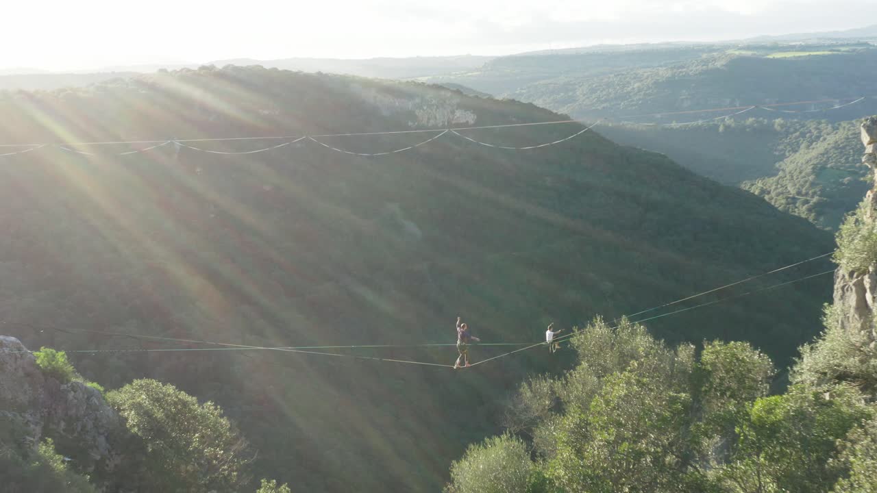 Mężczyzna idący po rozciągniętej linie – highline w górach – ujęcie z drona