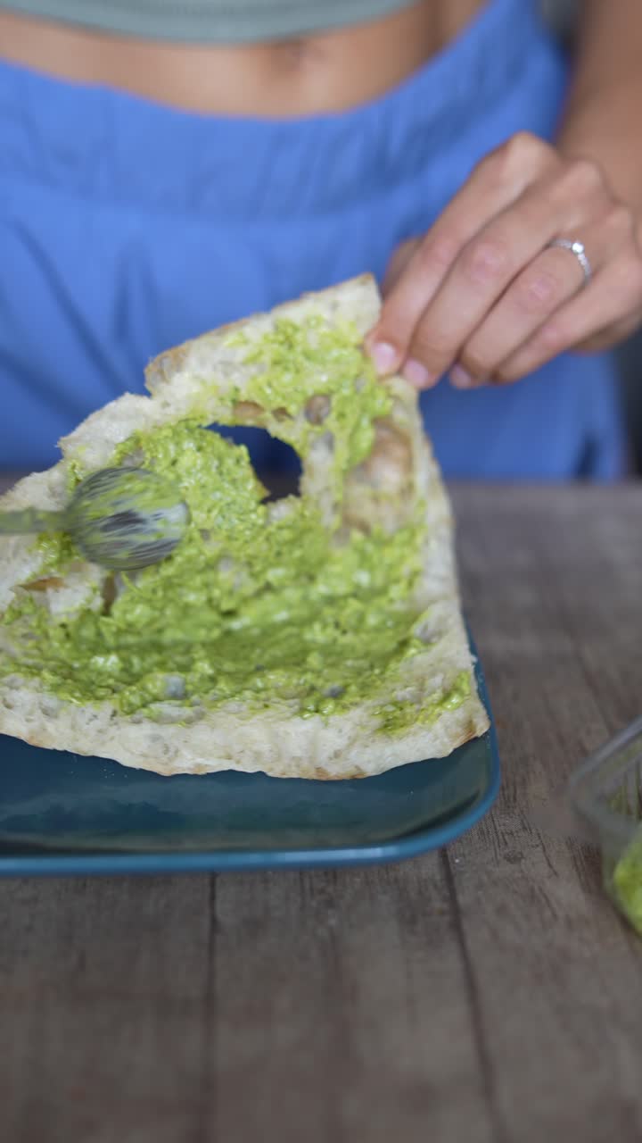 Donna che mangia una tartina al pesto
