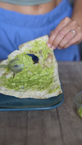 woman eating an open-faced pesto sandwich