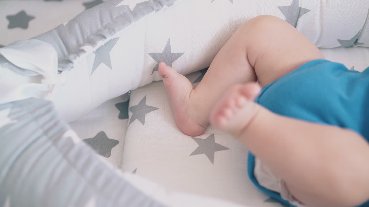 gambe fastidiose del neonato sdraiato in un morbido e confortevole bozzolo