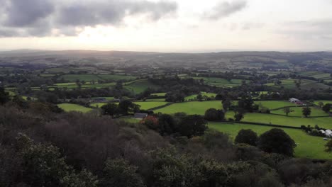 aerial rising reveal of idyllic farm fields in east hill devon