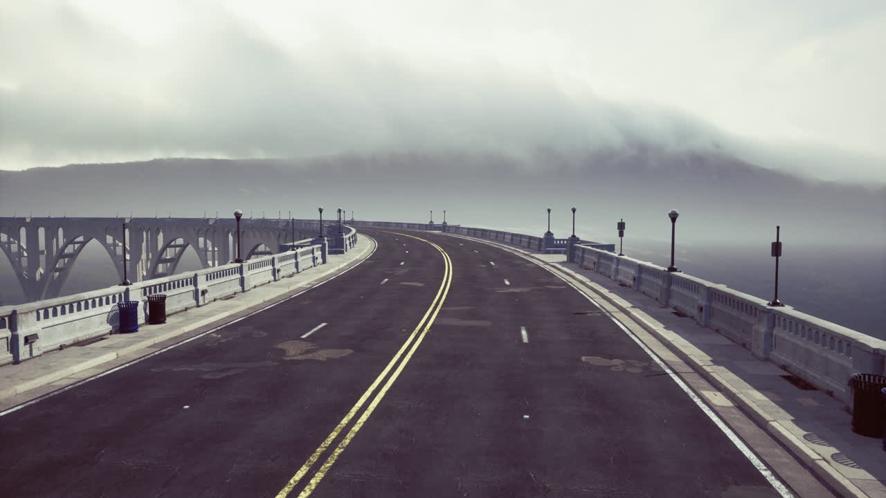 Foggy coastal highway leads to mysterious bridge in serene landscape view
