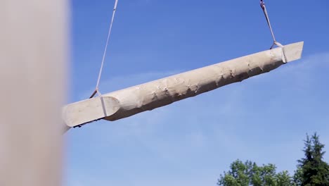 large wooden beam being lifted by crane