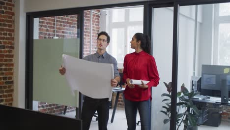 man and woman with plan document discussing and shaking hands at office