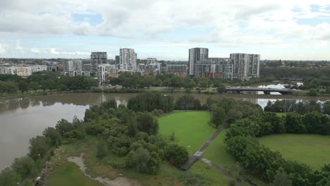 Aerial-Ascending-Reveals-Riverside-Apartment-Living-at-Wolli-Creek-from-Cooks-River,-Tempe,-Australia