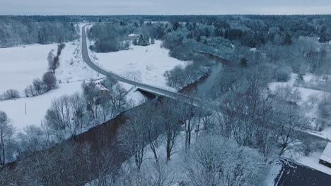 Verschneite-Landschaft-Mit-Abava-Fluss-In-Der-Nähe-Des-Dorfes-Renda-Im-Winter,-Luftaufnahme,-Vorwärts-Bewegen,-Nach-Unten-Neigen