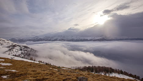 Lapso-De-Tiempo-De-Paisaje-De-Nubes-De-Invierno,-Saliendo-Sobre-El-Valle-Alpino-Y-Las-Montañas-Nevadas,-Vista-Panorámica