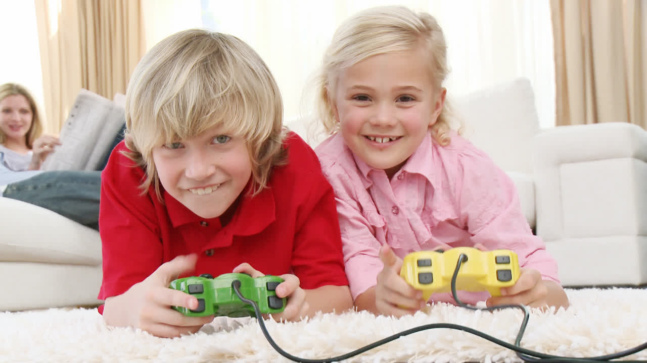 Kinder spielen Videospiele und Eltern sitzen auf dem Sofa.