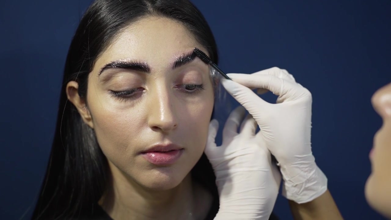 Microblading Magic: Brushing and Oiling the Perfect Brows Closeup of Young Woman's Face