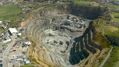 Arbeiten-Im-Granitsteinbruch-Aus-Der-Luft-Mit-Maschinen-Und-Fahrzeugen-An-Einem-Hellen-Tag