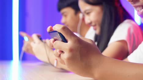 hands of asian esport team gamers playing in competitive video games on a cyber games tournament by mobile phone