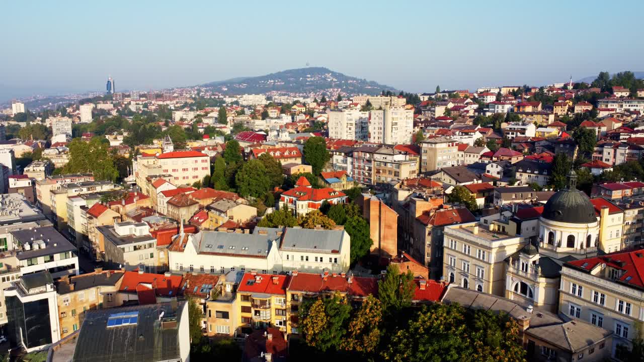 Vídeos stock de drone da cidade de Sarajevo ao nascer do sol na Bósnia e Herzegovina. Vista aérea do centro histórico da cidade, colinas circundantes, névoa matinal e luz quente, ideal para projetos de viagem e turismo