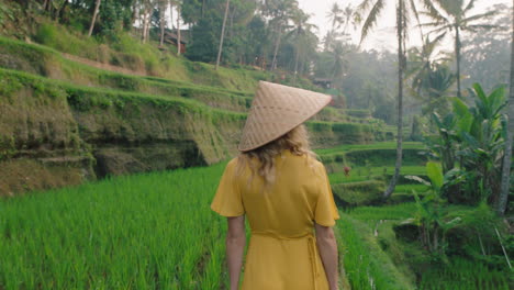 Mujer-De-Viaje-En-Arrozal-Con-Vestido-Amarillo-Con-Sombrero-Explorando-Una-Exuberante-Terraza-De-Arroz-Verde-Caminando-En-Un-Paisaje-Cultural-Vacaciones-Exóticas-A-Través-De-Bali-Indonesia-Descubrir-Asia