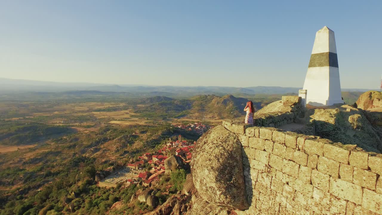 Aerial view of a historical site with a woman on the top of a rock formation