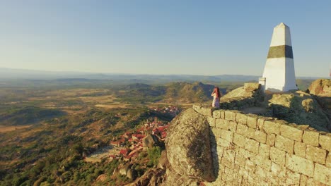 aerial view of a historical site with a woman on the top of a rock formation