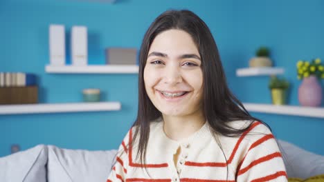 mujer joven sonriente con aparatos ortopédicos mirando a la cámara.