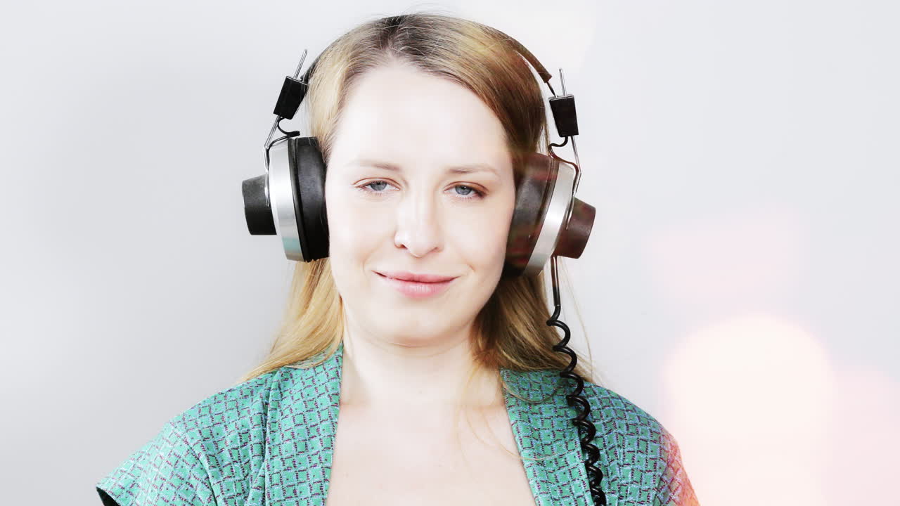 cool female dancer with changing retro headphones to listen to music