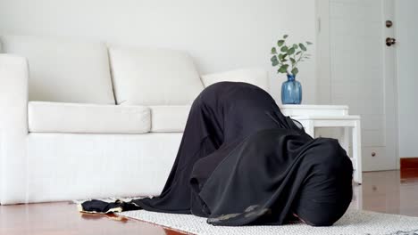 asian muslim woman praying and prostrating at home