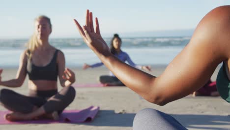 grupo de diversas amigas meditando en la playa