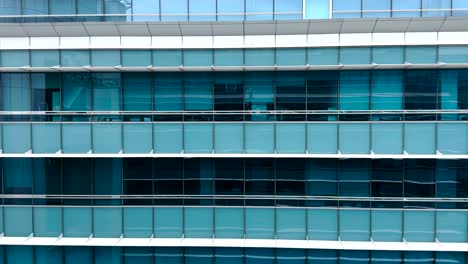 passing by a corporate blue building in singapore while gliding in a cable car - pov