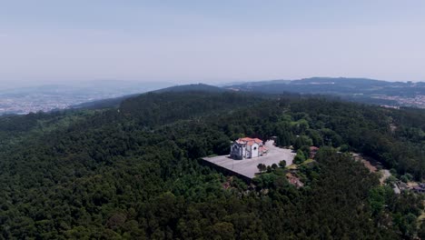 church with red roof on forested mountain plateau near Porto city